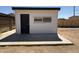 A single-story building with a door and barred window, possibly used for storage at 2745 E Wood St, Phoenix, AZ 85040