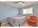 This bedroom has tile floors, a ceiling fan, and an orange armchair at 2823 W Banff Ln, Phoenix, AZ 85053