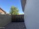 Side yard featuring a painted brick wall and a dark iron gate, offering a secure boundary with minimal maintenance at 2823 W Banff Ln, Phoenix, AZ 85053