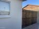 Side yard featuring a white painted brick wall and a well-maintained wooden gate, ensuring privacy and security at 2823 W Banff Ln, Phoenix, AZ 85053