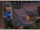 Aerial view of a home featuring a pool, putting green, and manicured backyard at dusk at 3119 E Bellflower Dr, Gilbert, AZ 85298