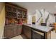 Basement bar features wood cabinets, granite countertop, wine rack and beverage fridge for entertaining at 3119 E Bellflower Dr, Gilbert, AZ 85298