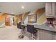Finished basement bar area boasts stylish seating, sleek countertops, and distinctive wall art at 3119 E Bellflower Dr, Gilbert, AZ 85298