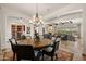 Elegant dining room with a round wood table, ornate chandelier, and seamless flow into the living area at 3119 E Bellflower Dr, Gilbert, AZ 85298