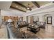 Spacious living room featuring dark leather sofas, wood beam ceiling accents, and an open floor plan at 3119 E Bellflower Dr, Gilbert, AZ 85298