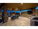 Covered outdoor kitchen and entertainment area with stone accents, a fireplace, TV, and ample seating at 3119 E Bellflower Dr, Gilbert, AZ 85298