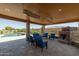 Inviting covered patio with comfortable seating, a stone fireplace, and a view of the pool and backyard at 3119 E Bellflower Dr, Gilbert, AZ 85298
