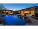 Backyard view of the pool at twilight, showcasing the outdoor kitchen and lush landscaping at 3119 E Bellflower Dr, Gilbert, AZ 85298