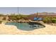 Sparkling pool with a unique swim-up bar and rock waterfall, set against a backdrop of desert landscaping at 3119 E Bellflower Dr, Gilbert, AZ 85298