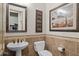 Powder room features a pedestal sink, tiled walls, and tasteful decor for a polished look at 3119 E Bellflower Dr, Gilbert, AZ 85298