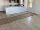Spacious living room with tile flooring, bright white walls and a large opening to the kitchen at 32016 N Pony Express Rd, San Tan Valley, AZ 85143