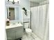 A well-maintained bathroom features a shower-tub combo, modern vanity, and a functional storage cabinet at 3408 N 69Th Dr, Phoenix, AZ 85033
