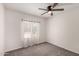 Bright bedroom with neutral carpet, ceiling fan, and sheer curtains at 3408 N 69Th Dr, Phoenix, AZ 85033