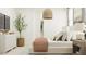 Serene bedroom with a stylish bed, ample natural light, and a decorative tree at 36550 W Maddaloni Ave, Maricopa, AZ 85138