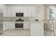 Bright kitchen featuring white cabinets, stainless steel appliances, and an island with seating at 36550 W Maddaloni Ave, Maricopa, AZ 85138
