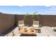 Charming patio area featuring comfortable seating, a wooden table, and stylish decor in a private backyard setting at 36600 W Maddaloni Ave, Maricopa, AZ 85138