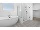Bathroom featuring a stand alone shower, tub, patterned tile flooring, and black accents at 37695 W Santa Maria St, Maricopa, AZ 85138