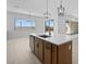 View of a kitchen island with a sink, wooden cabinets, and pendant lighting with glass doors to the back patio at 37695 W Santa Maria St, Maricopa, AZ 85138