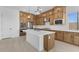A modern kitchen features light wood cabinets, stainless steel appliances, an island, and pendant lights at 37695 W Santa Maria St, Maricopa, AZ 85138