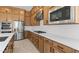 Close-up of a kitchen with wooden cabinets, stainless steel appliances, white countertops, and subway tile backsplash at 37695 W Santa Maria St, Maricopa, AZ 85138