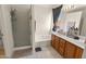 Bathroom features a tub, shower stall, tiled flooring, and a vanity with natural wood finish at 3871 W Linda Ln, Chandler, AZ 85226