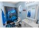 Blue-themed bathroom includes modern vanity, unique round window, and tub with themed shower curtain at 3871 W Linda Ln, Chandler, AZ 85226