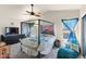 A well-lit bedroom with a four poster bed, ceiling fan, and sitting area at 3871 W Linda Ln, Chandler, AZ 85226