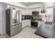 Updated kitchen features stainless steel appliances, white cabinetry, tile flooring, and colorful backsplash at 3871 W Linda Ln, Chandler, AZ 85226