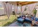 Cozy outdoor patio area with comfortable blue wicker seating, privacy curtains, and green grassy area at 3871 W Linda Ln, Chandler, AZ 85226