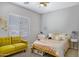 Cozy bedroom with a ceiling fan, large window, and charming yellow couch at 4231 E Augusta Ave, Chandler, AZ 85249