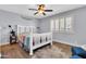 Bright bedroom featuring a white bed frame, ceiling fan, hardwood floors, and a shuttered window at 4363 E Dragoon Cir, Mesa, AZ 85206