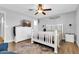Well-lit bedroom with hard wood flooring, ceiling fan, white dresser and bed frame, and television at 4363 E Dragoon Cir, Mesa, AZ 85206