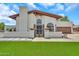 Inviting home featuring a well-kept lawn and an elegant entrance with decorative wrought iron gate at 4601 E Carolina Dr, Phoenix, AZ 85032