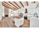 Open concept kitchen with island, stainless appliances, white cabinets and wood floors at 4601 E Carolina Dr, Phoenix, AZ 85032