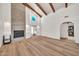 Cozy living room featuring a brick fireplace, arched doorways, and hardwood flooring at 4601 E Carolina Dr, Phoenix, AZ 85032