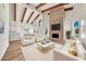 Elegant living room with high ceilings, exposed beams, fireplace, and stylish white furniture at 4601 E Carolina Dr, Phoenix, AZ 85032