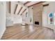 Spacious living room with a vaulted ceiling, wood beams, fireplace, and light wood-look flooring at 4601 E Carolina Dr, Phoenix, AZ 85032