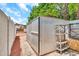 Outdoor metal storage shed with an open door surrounded by a stone path and greenery at 4601 E Carolina Dr, Phoenix, AZ 85032