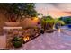 Landscaped backyard oasis with stone accents, vibrant plants, and ambient lighting at 4618 W Pokeberry Ln, Phoenix, AZ 85083