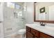 Modern bathroom features white marbled tile shower and a wood vanity with a large mirror at 4618 W Pokeberry Ln, Phoenix, AZ 85083