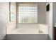 Soaking tub with privacy glass block window and a view of the outdoors at 4618 W Pokeberry Ln, Phoenix, AZ 85083