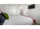 Simple bedroom with a white bed, sliding closet doors and a TV on the wall at 4618 W Pokeberry Ln, Phoenix, AZ 85083