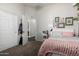 Cozy bedroom with pink accents, framed decor and an adjoining bathroom entrance with closet at 4618 W Pokeberry Ln, Phoenix, AZ 85083