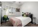 Neutral bedroom with a white bed, dark accents and a window dressed with shutters at 4618 W Pokeberry Ln, Phoenix, AZ 85083