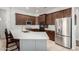 Well-equipped kitchen featuring stainless steel appliances, dark wood cabinets, and an island with bar seating at 4618 W Pokeberry Ln, Phoenix, AZ 85083