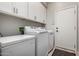 Functional laundry room with upper cabinets, modern washer and dryer and extra freezer storage at 4618 W Pokeberry Ln, Phoenix, AZ 85083