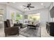 Comfortable living room featuring a ceiling fan, neutral decor, and bright windows at 4618 W Pokeberry Ln, Phoenix, AZ 85083