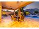 Covered patio with comfortable seating overlooks a stunning pool and beautifully landscaped backyard at 4618 W Pokeberry Ln, Phoenix, AZ 85083