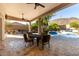 Covered patio with comfortable seating overlooks a stunning pool and beautifully landscaped backyard at 4618 W Pokeberry Ln, Phoenix, AZ 85083
