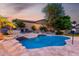 Sparkling pool with stone accents, raised spa, and mature landscaping in a private backyard at 4618 W Pokeberry Ln, Phoenix, AZ 85083